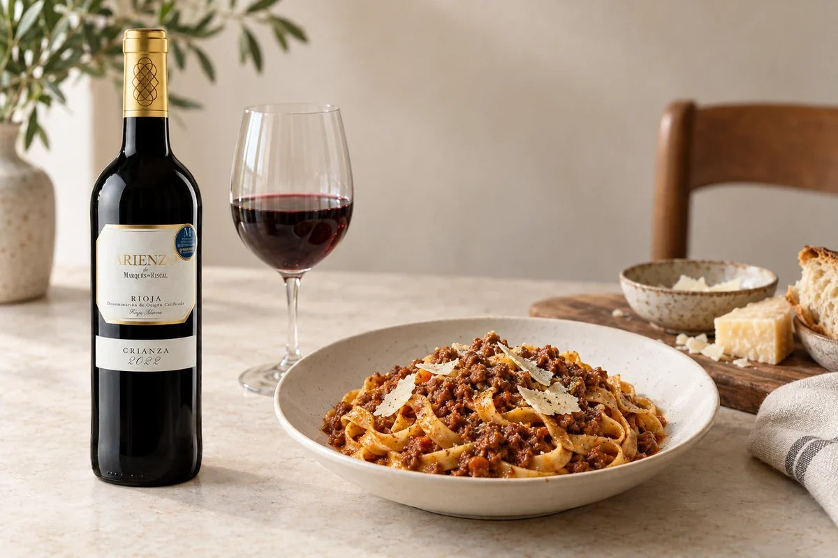 Tagliatelle med kødragù og parmesan ved siden af Arienzo Rioja Crianza 2022 og et glas rødvin