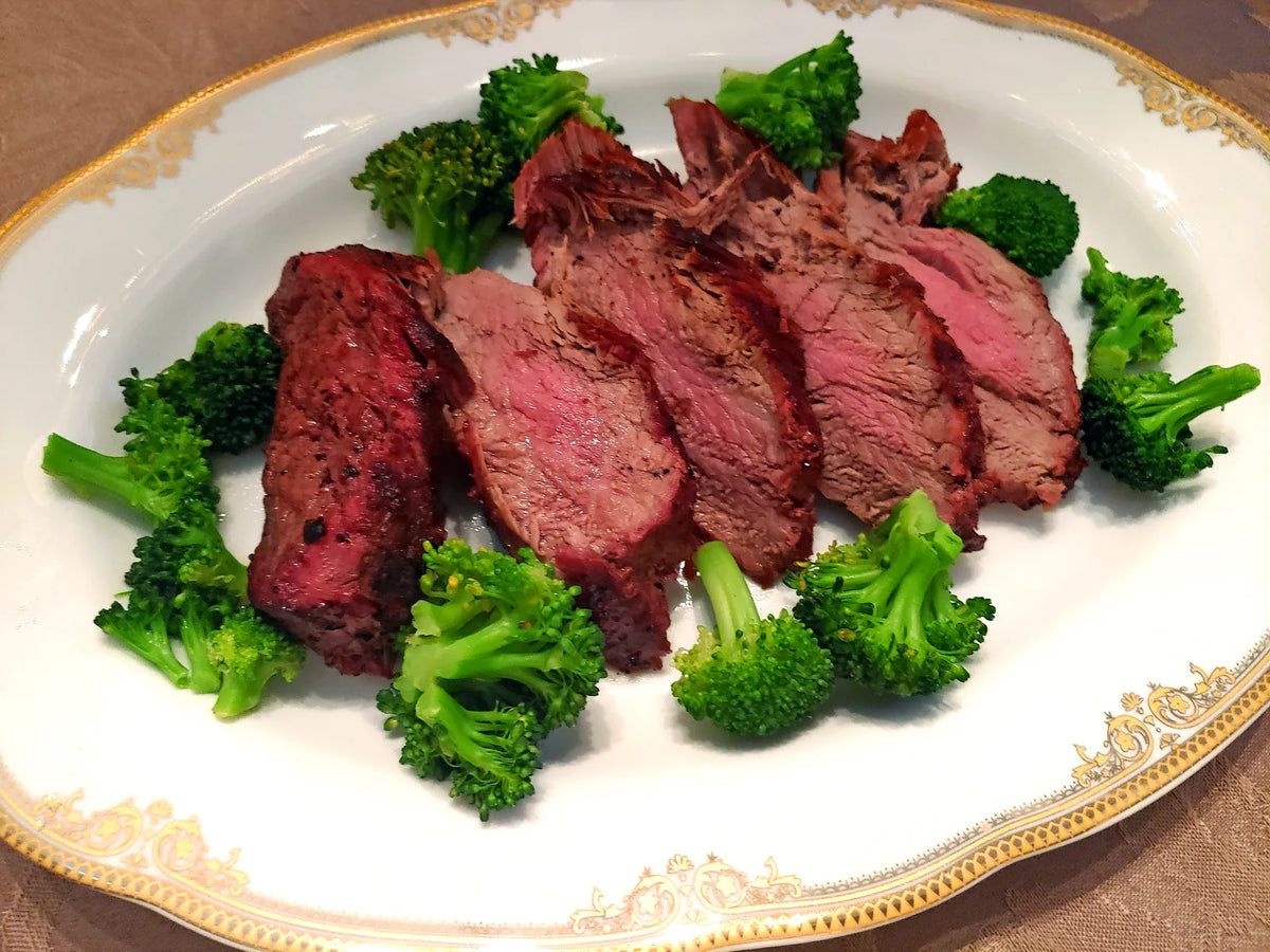 Chateaubriand af oksemørbrad skåret i skiver og serveret med broccoli på et fad