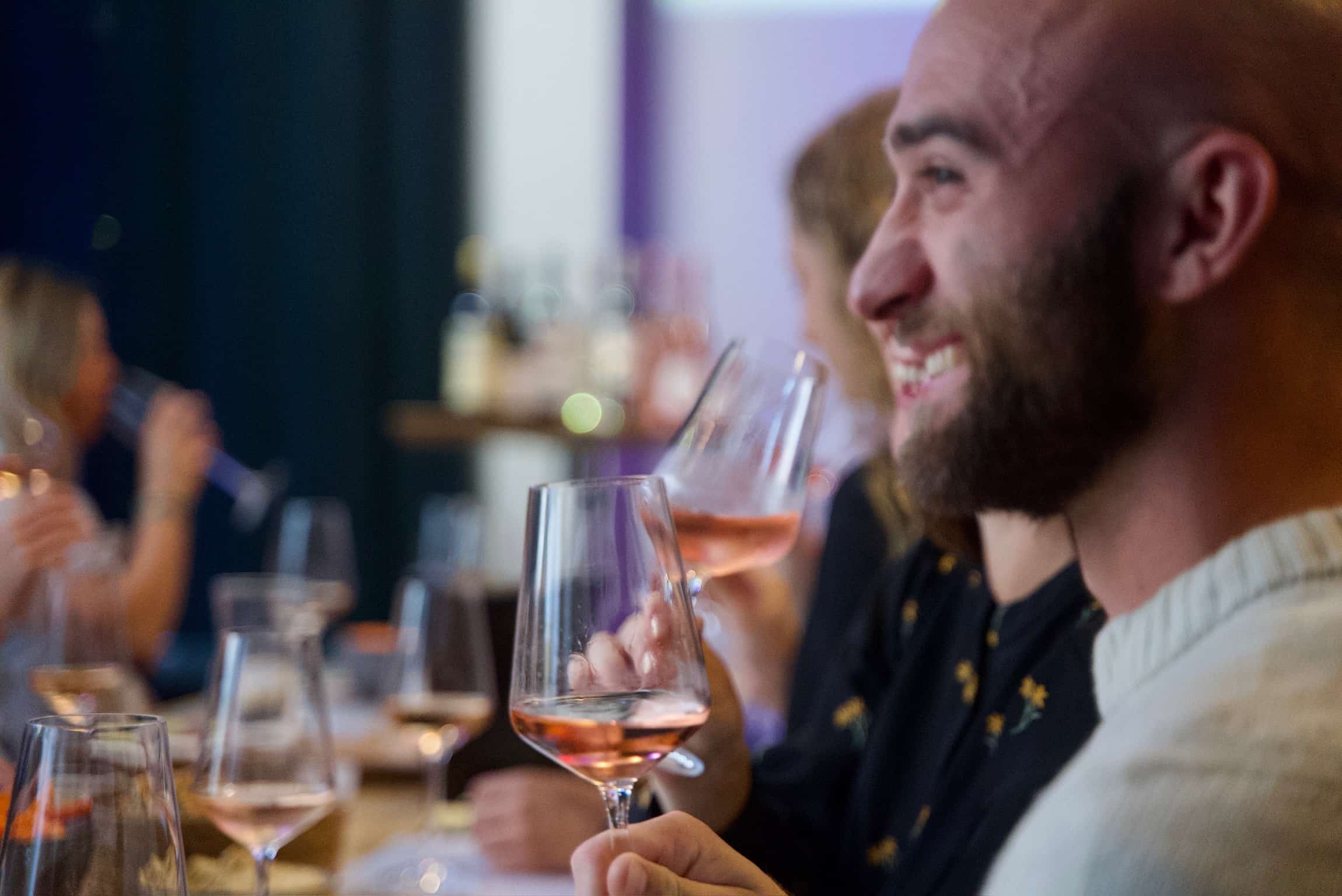 Glad gæst nyder et glas spansk rosévin og den gode stemning til en vinsmagning hos DeVinos i Aarhus.