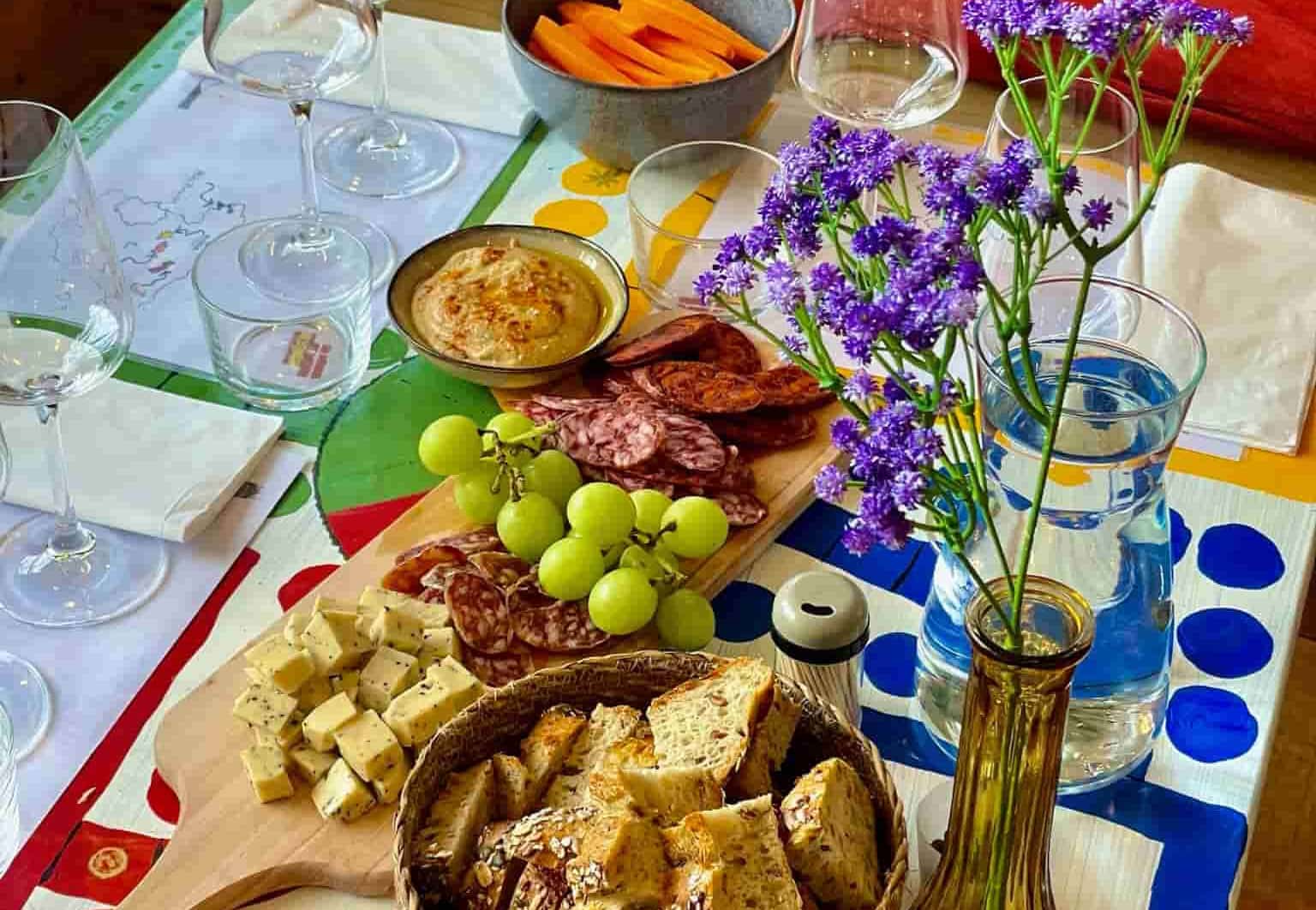 Nøje udvalgt spansk tapas anretning med specialiteter som chorizo, ost og druer, serveret til en vinsmagning hos DeVinos i Aarhus.